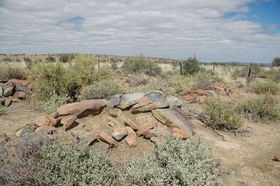The Varsche Fontein cemetery looking across it: low rectangular cairns of local stone, several of them, most with no...